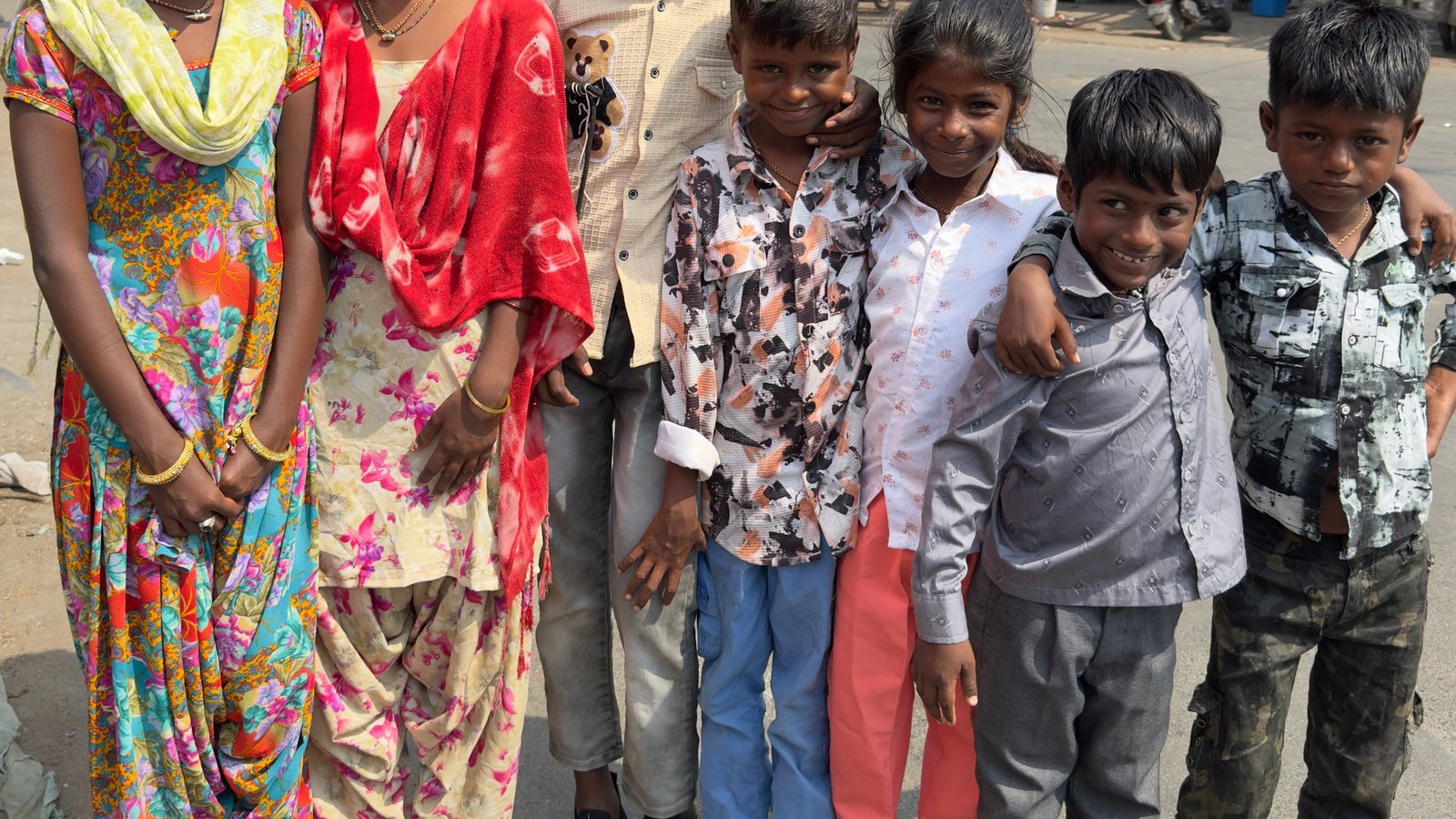 Children smiling proudly with new school shoes and educational supplies from Nai Raah Foundation